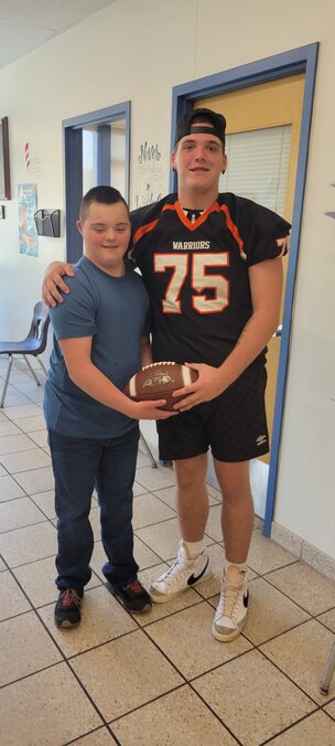 Walton varsity football player Anthony Soto presents football fan Parker MacGibbon with a used game ball Friday, Oct. 27.